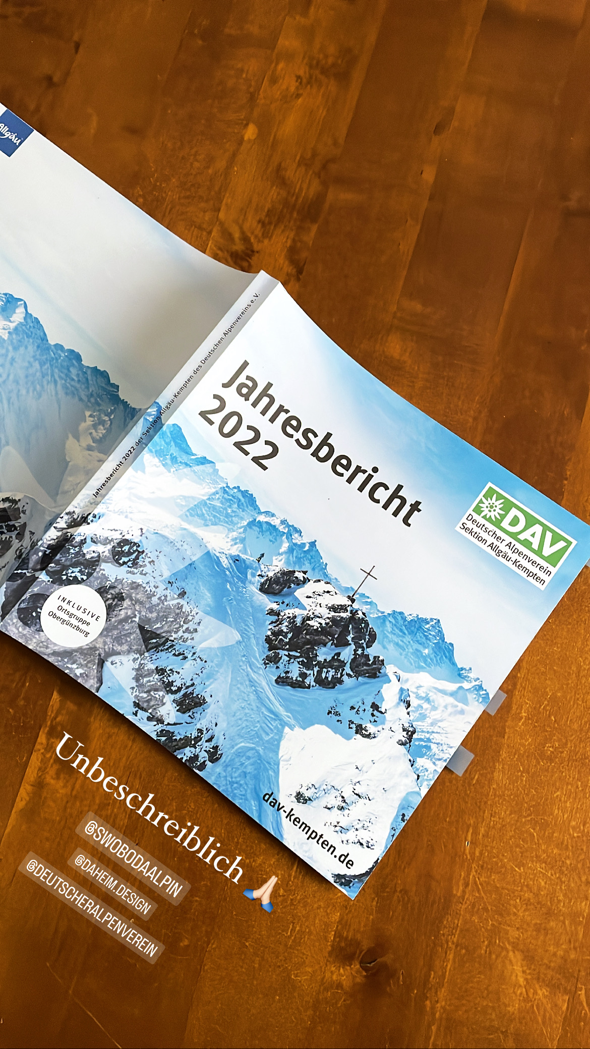 Coverbild des Jahresberichts 2022 vom DAV Kempten mit Bergsilhouette, Gipfelkreuz im Winter