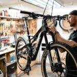 Businessfotografie eines Mannes nimmt letzte handwerkliche Handgriff zum fertigstellen eines hochwertigen Fahrrads von NoName Bikes