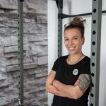 Personal Branding Businessfotografie Portrait einer Frau angelehnt an ein Fitnessgerät