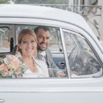 Hochzeitsfoto eines Brautpaares im in einem VW Käfer