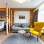 Interieurfotografie eines Hotelzimmers mit Sessel, Couch und Bett schön Design für die Hotelfotografie