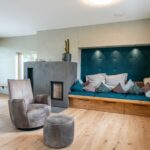 Interieurfotografie des Wohnraumes mit Sitzecke, Holzofen und Sessel