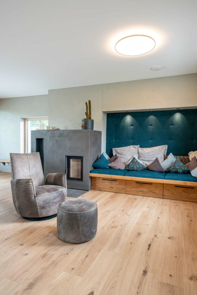 Interieurfotografie des Wohnraumes mit Sitzecke, Holzofen und Sessel