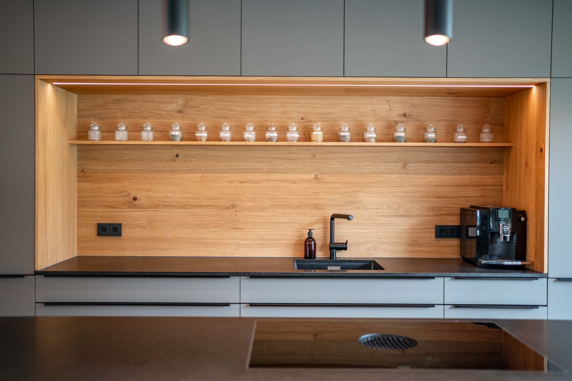 Interieurfotografie einer schön designten Küche mit Kochinsel und Holzelementen